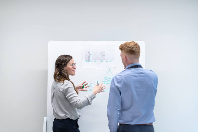 engineer discusses data in meeting with colleague